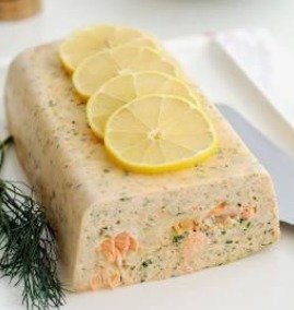 Pain de poisson blanc doré au four, servi en tranches épaisses avec une sauce crémeuse à l'aneth et des rondelles de citron.